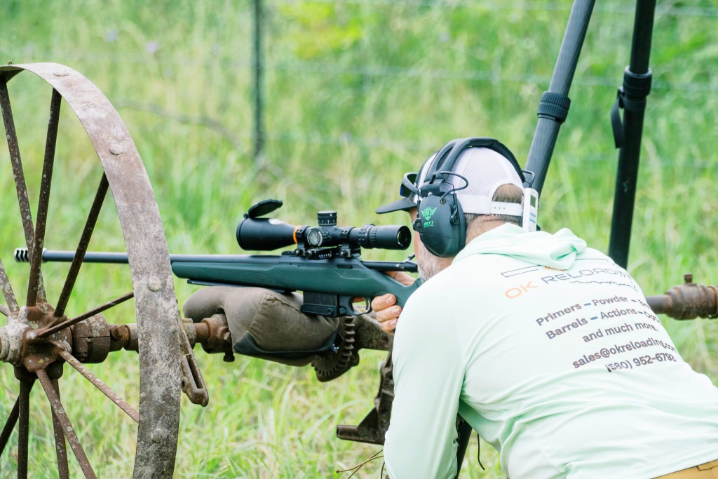 Shooter engaging a target from an improvised position on old farm equipment during an NRL Hunter match.