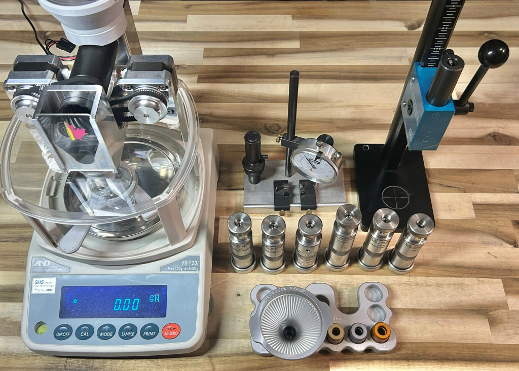 Precision reloading equipment including a powder scale, dies, measuring tools, and press