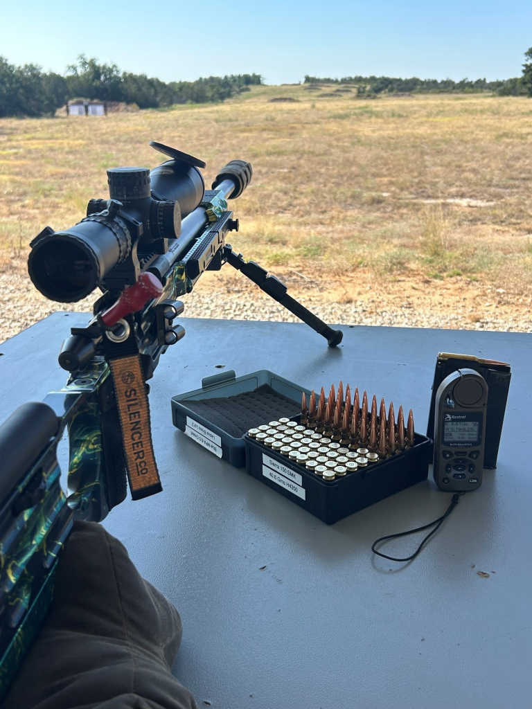 Precision rifle, ammunition, and Kestrel weather meter on a long-range shooting range
